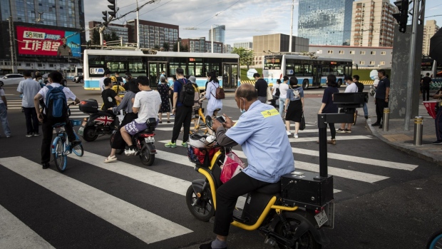 Commuters wait at a traffic intersection in Beijing, China, on Wednesday, Aug. 25, 2021. China's Communist Party vowed to promote the welfare of all people and redistribute income, underscoring its push to achieve "common prosperity" in the country. Photographer: Qilai Shen/Bloomberg