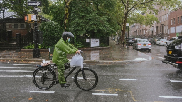 A delivery rider during tropical storm Henri in the Brooklyn borough of New York, U.S., on Sunday, Aug. 22, 2021. Henri weakened to a tropical storm as its track jogged a bit east, but remains set to unleash flooding rains and dangerous storm surges across a wide arc from New York to Boston. Photographer: Ismail Ferdous/Bloomberg