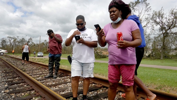 LAPLACE, LOUISIANA - AUGUST 30: Residents gather long a set of railroad tracks to try and get cell phone service after their community was heavily damaged by Hurricane Ida on August 30, 2021 in Laplace, Louisiana. Ida made landfall yesterday as a category 4 storm southwest of New Orleans. (Photo by Scott Olson/Getty Images)