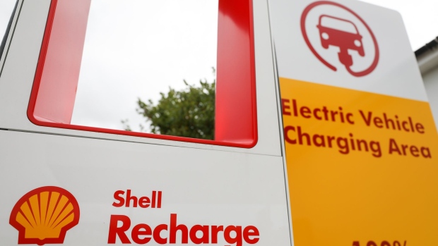 A sign for an electric vehicle charging area stands at a Royal Dutch Shell Plc petrol filling station in Ewell, U.K., on Wednesday, Sept. 30, 2020. Royal Dutch Shell Plc will cut as many as 9,000 jobs as Covid-19 accelerates a company-wide restructuring into low-carbon energy. Photographer: Chris Ratcliffe/Bloomberg