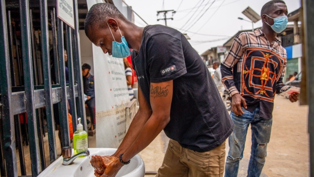A shopper stops to wash his hands at the entrance to a market in Lagos, Nigeria, on Monday, March 29, 2021. Nigerians are having to contend with the highest inflation rate in four years, the second-highest unemployment rate on a list of 82 countries tracked by Bloomberg, and an economy that’s only just emerged from recession.
