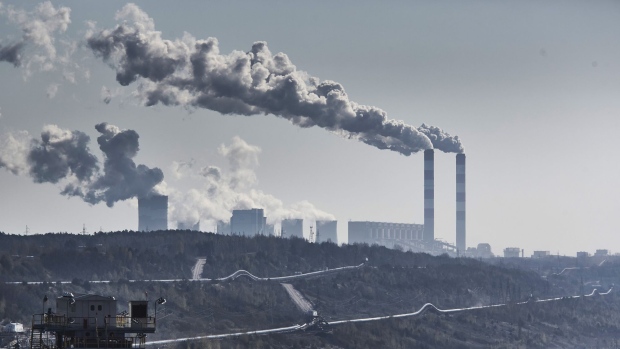 Vapor rises from chimneys and cooling towers at the Belchatow coal powered power plant beyond an open cast lignite mine, operated by PGE SA, in Belchatow, Poland, on April 28, 2021. Photographer: Bartek Sadowski/Bloomberg