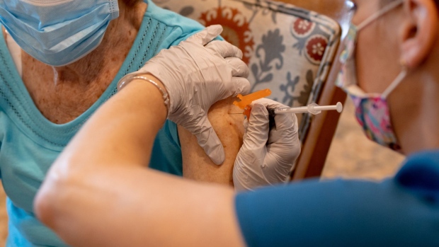 A healthcare worker administers a third dose of the Pfizer-BioNTech Covid-19 vaccine at a senior living facility in Worcester, Pennsylvania, U.S., on Wednesday, Aug. 25, 2021. Pfizer Inc. and BioNTech SE are seeking full U.S. approval for a Covid-19 booster shot for people 16 and older, asking regulators to sign off on a third dose to quell a rise in infections among vaccinated people. Photographer: Hannah Beier/Bloomberg