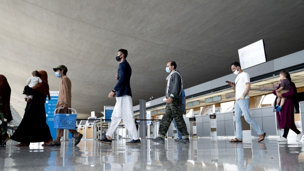 Refugees from Afghanistan walk through Washington Dulles International Airport in Dulles, Virginia, U.S., on Tuesday, Aug. 31, 2021. The departure of the last U.S. military plane from Afghanistan left the region facing uncertainty, with the Taliban seeking to cement control of a nation shattered by two decades of war and an economy long dependent on foreign aid and opium sales. Photographer: Stefani Reynolds/Bloomberg