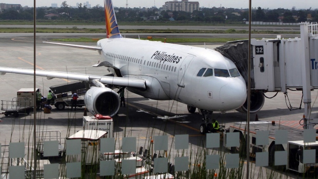 A Philippine Airlines Inc. airplane sits on the tarmac at Terminal 2 of Ninoy Aquino International Airport (NAIA) in Manila, the Philippines, on Thursday, Dec. 23, 2010. Philippine Airline is the nation's biggest carrier. Photographer: Edwin Tuyay/Bloomberg