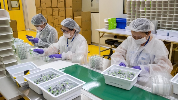Workers wearing protective equipment on the Medigen Vaccine Biologics Corp. (MVC) COVID-19 vaccine packaging line in the company's laboratory in Hsinchu, Taiwan.