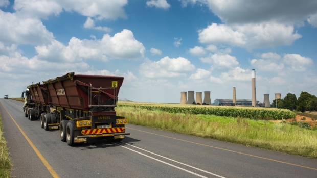 A coal delivery truck passes the Komati coal-fired power station, operated by Eskom Holdings SOC Ltd., in Mpumalanga, South Africa, on Tuesday, Jan. 12, 2021. In South Africa, for decades almost all the electricity needed to power Africa’s most industrialized economy has been produced by a fleet of aging coal-fired plants constructed alongside the mines to the east of Johannesburg. Photographer: Waldo Swiegers/Bloomberg