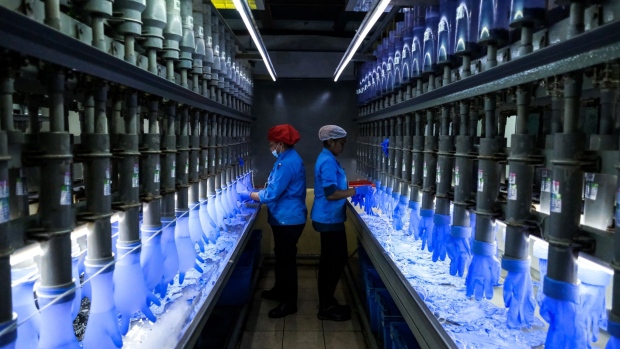 Employees check latex gloves in the watertight test room at a Top Glove Corp. factory in Setia Alam, Selangor, Malaysia, on Tuesday, Feb. 18, 2020. The world’s biggest glovemaker got a vote of confidence from investors in the credit market, as the coronavirus fuels demand for the Malaysian company’s rubber products. The World Health Organization is taking an unprecedented step of negotiating directly with suppliers to improve access to gloves, face masks and other forms of protective equipment.