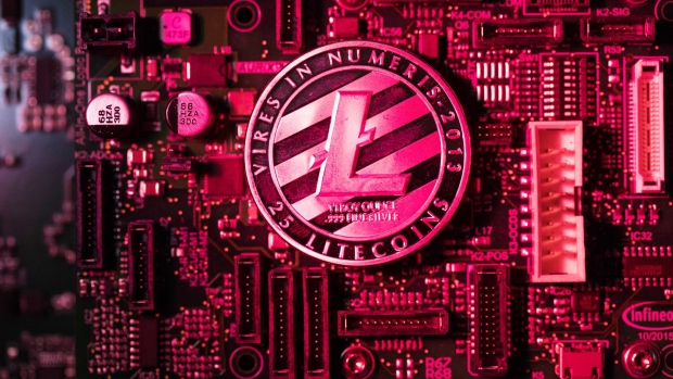A coin representing Litecoin cryptocurrency sits on a computer circuit board in this arranged photograph in London, U.K., on Tuesday, Feb. 6, 2018. Cryptocurrencies tracked by Coinmarketcap.com have lost more than $500 billion of market value since early January as governments clamped down, credit-card issuers halted purchases and investors grew increasingly concerned that last year’s meteoric rise in digital assets was unjustified. Photographer: Chris Ratcliffe/Bloomberg