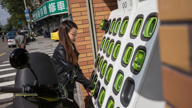A woman removes a Gogoro Inc. battery from a charging station in Taipei, Taiwan, on Monday, Jan. 22, 2018. Gogoro, the Taiwanese electric scooter maker backed by former U.S. Vice President Al Gore, sees the smog-choked streets of Southeast Asia as the ideal target market as it embarks on a quest to expand its business overseas.