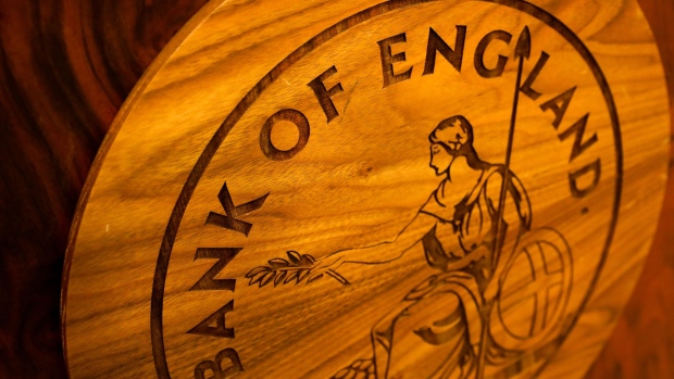 A wooden plaque of the Bank of England (BOE) logo sits on a desk ahead of the bank's quarterly inflation report news conference in the City of London,n, U.K., on Thursday, Aug. 2, 2018. The BOE lifted its benchmark interest rate to the highest since 2009 and policy makers put on a united front to say that further tightening will be needed to rein in inflation. Photographer: Simon Dawson/Bloomberg
