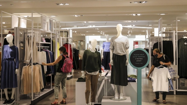 A sign displaying social distancing guidelines stands in the womenswear department inside a John Lewis Partnership Plc department store in London, U.K., on Thursday, July 23, 2020. U.K. Prime Minister Boris Johnson had resisted making masks mandatory until July 13, when his government announced that face coverings will be compulsory in stores as of July 24. Photographer: Simon Dawson/Bloomberg