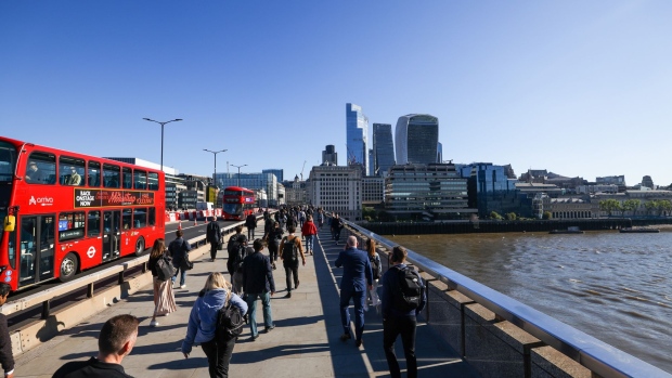 Commuters walk across London Bridge towards the City of London square mile financial district in London, U.K., on Thursday, May 27, 2021. More than half of workers in London's financial districts may now be traveling back into the office, the most since lockdown measures began easing in the U.K., according to rising sales of tuna baguettes and lattes. Bloomberg