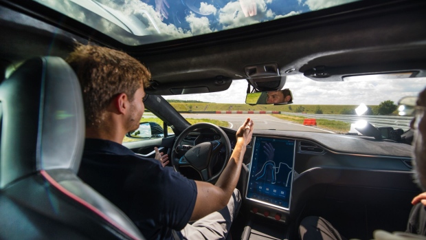 A test driver removes his hands from the steering wheel of a Tesla Motors Inc. Model S electric automobile fitted with self driving technology, developed by Robert Bosch GmbH, during the Bosch mobility experience in Boxberg, Germany, on Tuesday, July 4, 2017. Auto supplier Bosch will build a 1 billion-euro ($1.1 billion) semiconductor plant, the biggest single investment in its history, as the maker of brakes and engines prepares for a surge in demand for components used in self-driving vehicles.