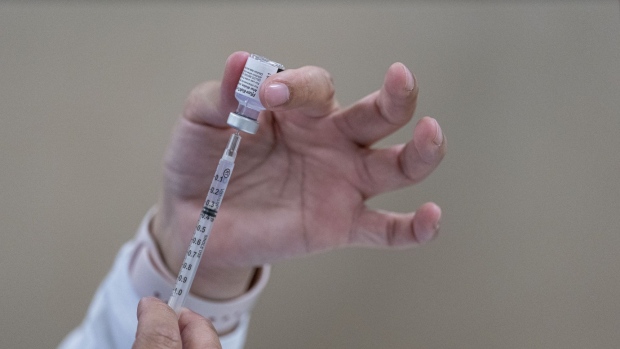 A healthcare worker fills a syringe with a dose of the Pfizer-BioNTech Covid-19 vaccine at a large scale vaccination site in Sacramento, California, U.S., on Thursday, Feb. 4, 2021. California reported 10,501 new cases Wednesday, compared with more than 50,000 a month ago. Photographer: David Paul Morris/Bloomberg