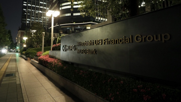 Signage is displayed outside the Mitsubishi UFJ Financial Group Inc. (MUFG) headquarters at night in Tokyo.