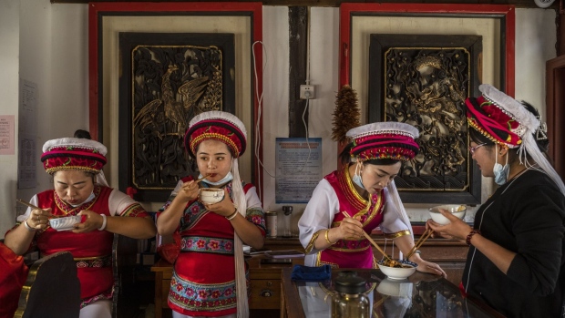 XIZHOU, CHINA - April 24: Tour guides from the Bai ethnic group eat lunch during a break at a local tourist site on April 24, 2021 in Xizhou, Yunnan province, China. Domestic tourism has shown signs of bouncing back as the pandemic is largely under control. (Photo by Kevin Frayer/Getty Images)