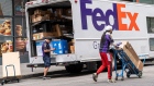 A driver for an independent contractor to FedEx scans packages outside a truck in San Francisco, California, U.S., on Monday, June 21, 2021. FedEx Corp. is expected to release earnings figures on June 24.