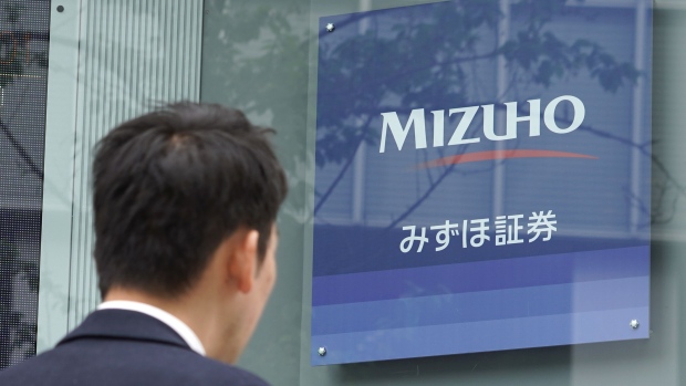 A pedestrian walks past a Mizuho Securities Co. branch, a unit of Mizuho Financial Group Inc., in Tokyo, Japan, on Tuesday, April 23, 2019. Mizuho Financial Group will announce its earnings figures on May 15. Photographer: Toru Hanai/Bloomberg