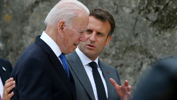 Emmanuel Macron, France's president, right, walks arm in arm with U.S. President Joe Biden, center, and Mario Draghi, Italy's prime minister, left, on the first day of the Group of Seven leaders summit in Carbis Bay, U.K., on Friday, June 11, 2021. 