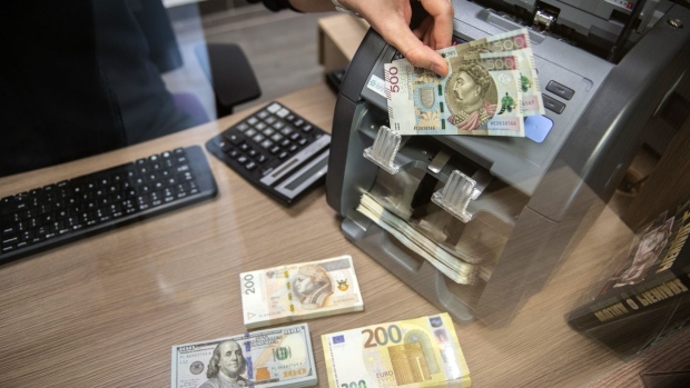 An employee places 500 zloty banknotes in a counting machine near stacks of U.S. dollars and euro banknotes in a currency exchange in Warsaw, Poland, on Tuesday, April 6, 2021. Poland's Central Bank’s Monetary Policy Council meets on Wednesday to set policy after the economy was hit with new restrictions in March to stop the spread of the Coronavirus pandemic. Photographer: Lukasz Sokol/Bloomberg