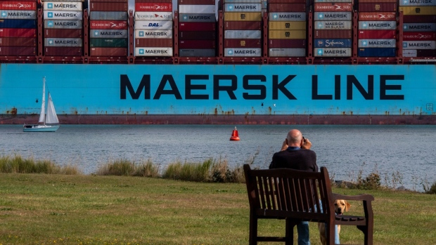 A sail boat passes a Maersk container ship at the Port of Felixstowe Ltd. in Felixstowe, U.K.