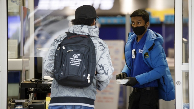 An employee wearing a protective mask assists a customer with a curb-side pickup order at a Best Buy Co. Inc. store in Toronto, Ontario, Canada, on Monday, Nov. 23, 2020. Canada's largest province ordered a lockdown in Toronto and one of its suburbs, a declaration that forces shopping malls, restaurants and other businesses to close their doors to slow a second wave of coronavirus cases. Photographer: Cole Burston/Bloomberg