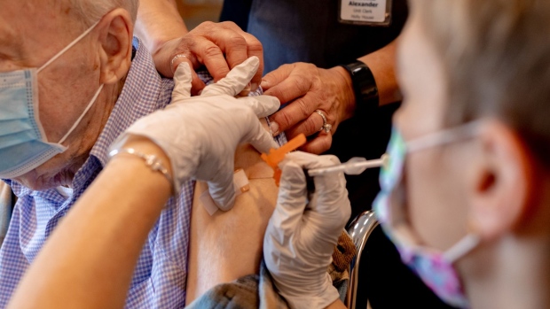 A healthcare worker administers a third dose of the Pfizer-BioNTech Covid-19 vaccine at a senior living facility in Worcester, Pennsylvania, U.S., on Wednesday, Aug. 25, 2021. Pfizer Inc. and BioNTech SE are seeking full U.S. approval for a Covid-19 booster shot for people 16 and older, asking regulators to sign off on a third dose to quell a rise in infections among vaccinated people. Photographer: Hannah Beier/Bloomberg