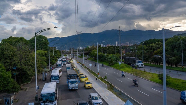 Taxis and buses wait on a highway in Medellin, Colombia, on Thursday, May 20, 2021. Colombia's dollar bonds dropped and the peso led losses among emerging-market currencies after S&P Global Ratings cut the country’s credit rating to junk amid a political crisis and mass unrest.