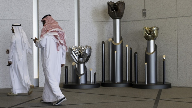 An employee checks his smartphone as he passes a display of drilling bits in the lobby of the Abu Dhabi National Oil Company (ADNOC) headquarters in Abu Dhabi, United Arab Emirates, on Thursday, Feb. 22, 2018. Adnoc is seeking to create world’s largest integrated refinery and petrochemical complex at Ruwais.