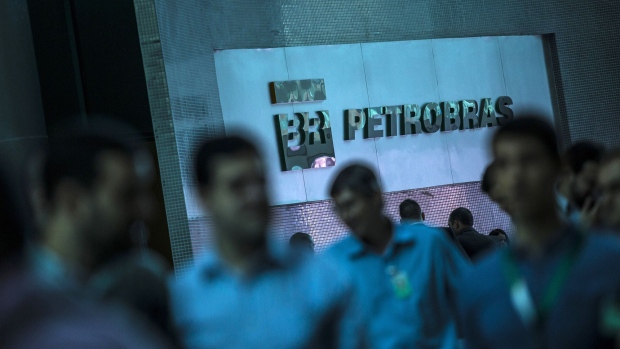 Workers move past Petroleo Brasileiro S.A. signage in the company's headquarters in Rio de Janeiro, Brazil. Photographer: Dado Galdieri/Bloomberg