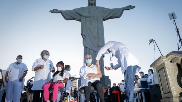A healthcare worker administers a dose of the Sinovac Biotech Ltd. coronavirus vaccine at the Christ the Redeemer statue in Rio de Janeiro, Brazil, on Monday, Jan. 18, 2021. Brazil accelerated plans to vaccinate its population against the coronavirus after an early start by the state of Sao Paulo added pressure on President Jair Bolsonaro to move faster to stem an incipient loss of popularity.