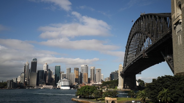 The Celebrity Solstice cruise ship, operated by Celebrity Cruises Inc., center left, sits moored at the Overseas Passenger Terminal as Sydney Harbor Bridge and commercial and residential buildings stand in the central business district in Sydney, Australia, on Thursday, April 13, 2017. The Australian economy will expand 2.5 percent in 2017, 2.8 percent in 2018 and 2.6 percent in 2019, according to a survey conducted by Bloomberg News. Photographer: Brendon Thorne/Bloomberg