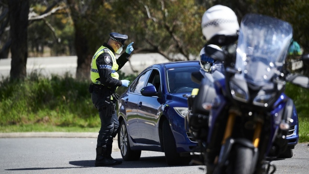 YASS, AUSTRALIA - SEPTEMBER 14: ACT Police perform checks on traffic on the NSW/ACT Border on on September 14, 2021. The Yass Valley council area will return to lockdown just three days after restrictions were eased for NSW regional towns following the discovery of a new COVID-19 case in the area. The snap two-week lockdown came into effect at 12.01am on Tuesday 14 September with residents subject to stay-at-home orders unless leaving for essential reasons. Face masks are compulsory in all indoor and outdoor areas. (Photo by Rohan Thomson/Getty Images)