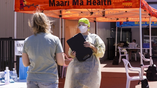 BROKEN HILL, AUSTRALIA - SEPTEMBER 24: A health worker checks in a woman at the Maara Ma COVID-19 testing clinic on September 24, 2021 in Broken Hill, Australia. Broken Hill remains in lockdown as the regional town records new COVID-19 cases in the community linked to the current Delta coronavirus outbreak in New South Wales. Residents in Broken Hill are subject to stay-at-home orders and are only permitted to leave home for essential reasons such as grocery shopping, accessing medical care or exercise. (Photo by Jenny Evans/Getty Images)