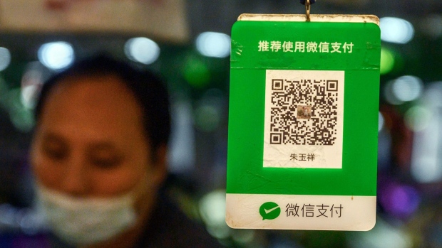 BEIJING, CHINA - SEPTEMBER 19: A Chinese vendor stands next to a QR code customers scan to pay via the WeChat app at a local market on September 19, 2020 in Beijing, China. The Trump administration announced Friday its intentions to ban the popular Chinese mobile app from U.S. app stores as of midnight on Sunday, marking an escalation in tensions with China on tech issues. The U.S. government said it also plans to prevent American companies from processing transactions made via the app. (Photo by Kevin Frayer/Getty Images)