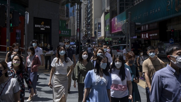 People walk along a street during lunch hour in Central district in Hong Kong, China, on Wednesday, Aug. 18, 2021. Hong Kong is caught between its desire to reopen and the government's zero tolerance for any cases of Covid-19, which has kept the virus out for most of the pandemic.