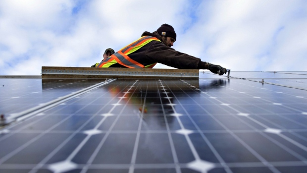 Dragonfly Solar contractor Aaron Anderson secures a solar panel during construction of a solar array for Heartland Power Cooperative in St. Ansgar, Iowa, U.S., on Friday, Jan. 23, 2015. Heartland Power Cooperative, one of over 900 electric cooperatives in the U.S., serves 5,200 members in northeast Iowa. The solar project will be comprised of 2,706 315-watt solar panels made by SolarWorld Corp., capable of generating approximately 852 kW of electricity.
