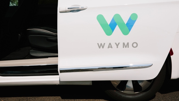 Waymo LLC signage is displayed on the open door of a Chrysler Pacifica autonomous vehicle in Chandler, Arizona, U.S., on Monday, July 30, 2018. The Google offshoot is tinkering with pricing and finalizing its business model for autonomous vehicles, which includes a new effort to boost public transit. Photographer: Caitlin O'Hara/Bloomberg