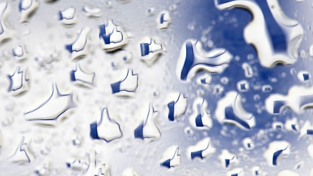 The Facebook Inc. 'like' logo is displayed on a computer screen and reflected in water droplets in San Francisco, California, U.S., on Thursday, May 17, 2012. Facebook Inc. rose in its trading debut following a record initial public offering that made the social network more costly than almost every company in the Standard & Poor's 500 Index. Photographer: Bloomberg/Bloomberg