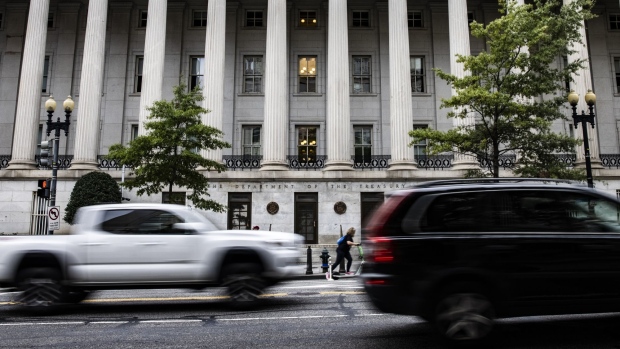 Vehicles pass in front of the U.S. Treasury building in Washington, D.C., U.S., on Sunday, Oct. 3, 2021. The global economy is entering the final quarter of 2021 with a mounting number of headwinds threatening to slow the recovery from the pandemic recession and prove policy makers' benign views on inflation wrong. Photographer: Samuel Corum/Bloomberg