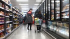 An employee walks past a customer browsing products in the frozen food aisle, during a time set aside for elderly and vulnerable members of the community to shop, at an Iceland Foods Ltd. store in London, U.K., on Wednesday, March 18, 2020. Growing fears about the coronavirus pandemic have led to extraordinary scenes in British grocery stores with people lining up outside shops before opening times and bulk-buying items such as toilet paper and pasta.