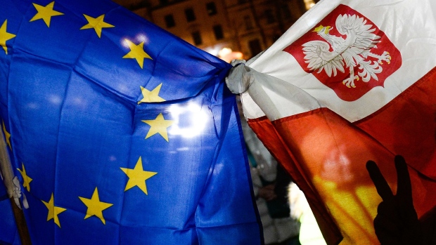 KRAKOW, POLAND - FEBRUARY 09: A hand gesticulates next to a Polish and European Union flag during a protest against the recently signed judiciary law by the Polish President Andrezj Duda at the Main Square on February 9, 2020 in Krakow, Poland. The so-called "muzzle law", allow the Law and Justice (PiS) government to discipline judges who question its judicial changes. The new draft order of the Vice-President of the Court of Justice of the European Union may impose two million euros fine a day in Poland if it "does not freeze" the activities of the Disciplinary Chamber of the Supreme Court - Rzeczpospolita Polish daily newspaper reported yesterday. (Photo by Omar Marques/Getty Images)