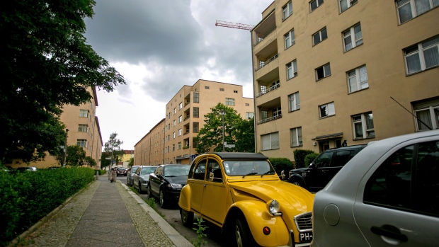 A classic Citroen 2CV automobile parked outside residential apartment blocks on the Carl Legien modernist housing estate, operated by Deutsche Wohnen SE, in Berlin, Germany, on Monday, Aug. 2, 2021. Vonovia SE nudged up its offer for rival German real estate company Deutsche Wohnen SE to about 19.1 billion euros ($22.7 billion), sweetening an attempt to woo shareholders after last month’s bid narrowly failed. Photographer: Krisztian Bocsi/Bloomberg
