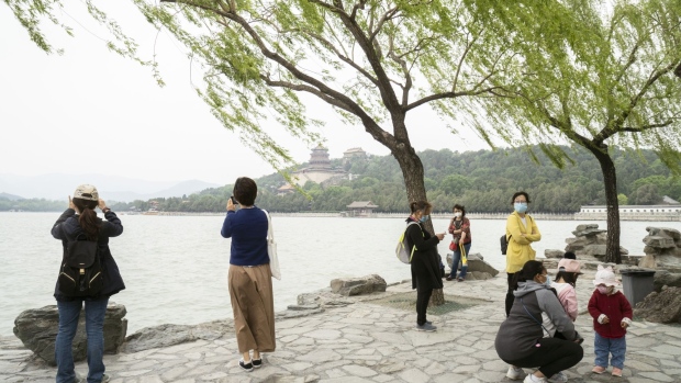 Visitors take photographs of Kunming Lake at the Summer Palace in Beijing, China, on Monday, May 4, 2020. As the Chinese capital prepares to host the nation's highest-profile political meeting this month, the city relaxed quarantine requirements for domestic travelers from low-risks areas since last Thursday, according to Chen Bei, deputy secretary-general for the Beijing municipal government. Photographer: Giulia Marchi/Bloomberg