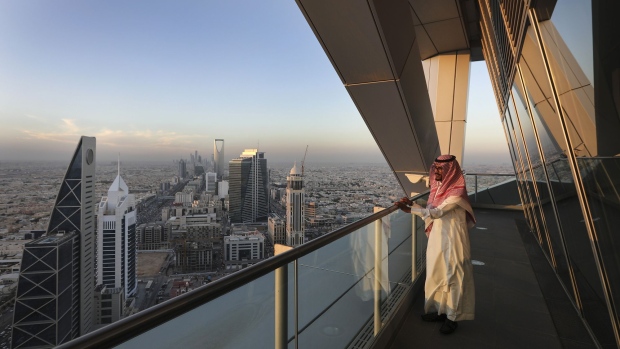 An employee looks out from the 32nd floor viewing platform of the Al Faisaliah Tower, as skyscrapers and commercial buildings stand beyond, in Riyadh, Saudi Arabia, on Thursday, Dec. 1, 2016. Saudi Arabia is working to reduce the Middle East’s biggest economy’s reliance on oil, which provides three-quarters of government revenue, as part of a plan for the biggest economic shakeup since the country’s founding.