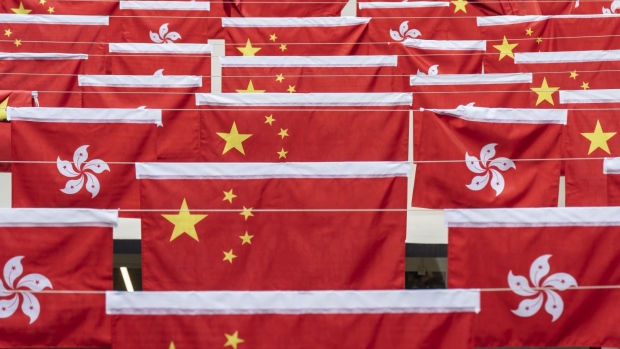 The flags of China and the Hong Kong Special Administrative Region (HKSAR) displayed at Central Market on National Day in Hong Kong, China, on Friday, Oct. 1, 2021. Hong Kong is putting more police on its streets during this years National Day celebrations than it did for the same holiday during historic unrest two years ago, evidence of the laser focus authorities are placing on eliminating any sign of dissent in the financial hub. Photographer: Chan Long Hei/Bloomberg