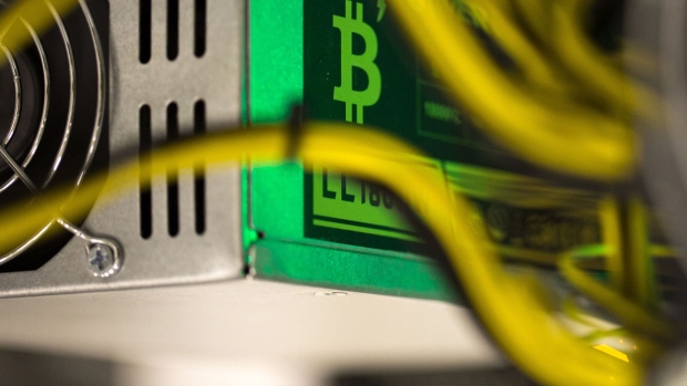 A bitcoin logo sits on a LL 1800W power unit supplying cryptocurrency mining machine. Photographer: Andrey Rudakov/Bloomberg