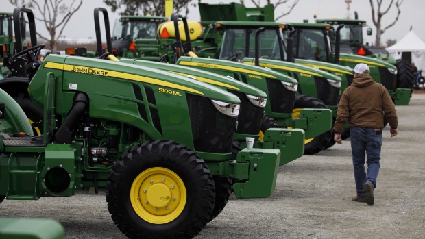 An attendee passes in front of Deere & Co. John Deere brand tractors displayed during the World Agriculture Expo in Tulare, California, U.S., on Tuesday, Feb. 12, 2019. The annual World AG Expo has more than 1,500 exhibitors displaying the latest in farm equipment, communications and technology on 2.6 million square feet of exhibit space. Photographer: Patrick T. Fallon/Bloomberg