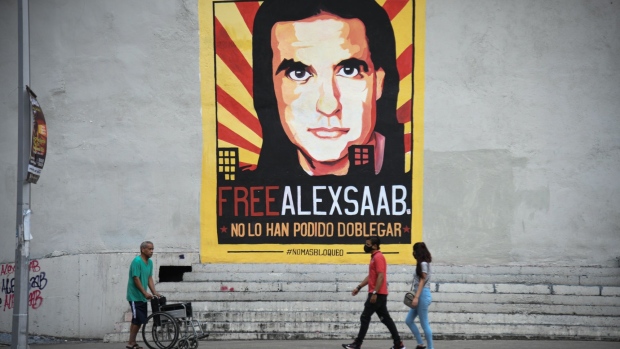 Pedestrians walk past a mural supporting jailed businessman Alex Saab in Caracas, Venezuela, on Friday, Sept. 17, 2021. Saab, a Colombian jailed in Cape Verde for alleged money laundering in his dealings with procuring food goods for a Venezuelan government program, is awaiting extradition to the U.S. after losing multiple appeals.
